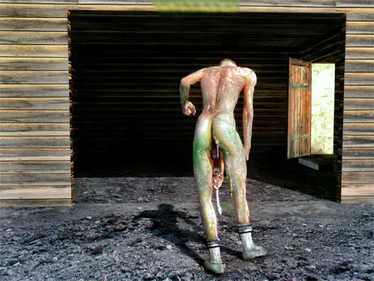 Naked man going into a barn