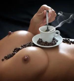 topless woman on her back with an espresso cup on her chest right below her hard-nippled tits