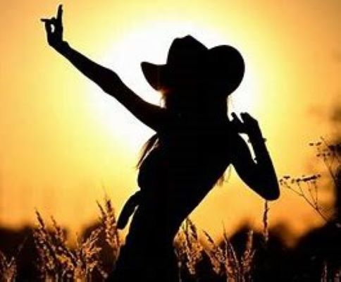 Silhouette of a cowgirl against the sunset