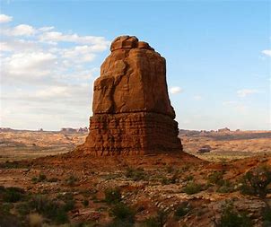 A huge rock in the middle of the desert
