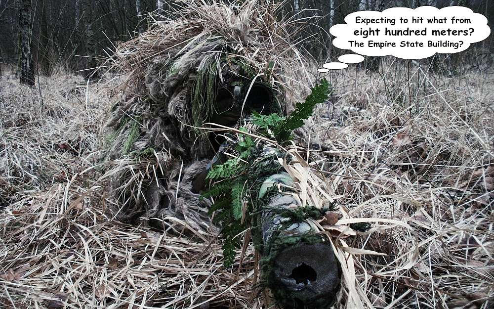 A heavily concealed sniper in a heap of dead leaves and straw. The barrel of the gun and blackened face under the heap of leaves, is in the foreground.