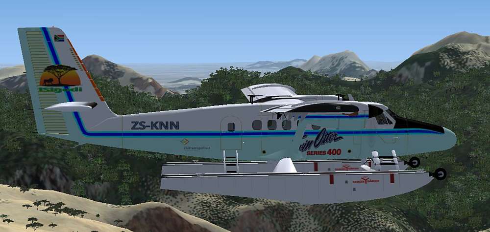 The DHC-6 Twin Turbo Otter series 400, painted in light powder blue and arctic white, with the iSigodi Logo on the tail fin, proudly displaying the registration: ZS-KNN, is seen flying with the high jagged peaks of the Hottentots Holland Mountains in the background.