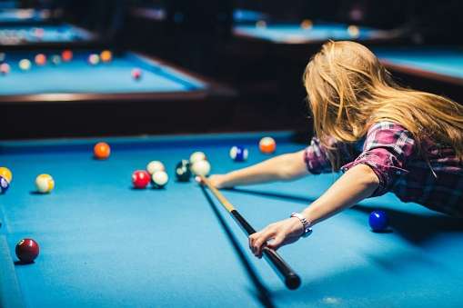 Blonde woman playing pool