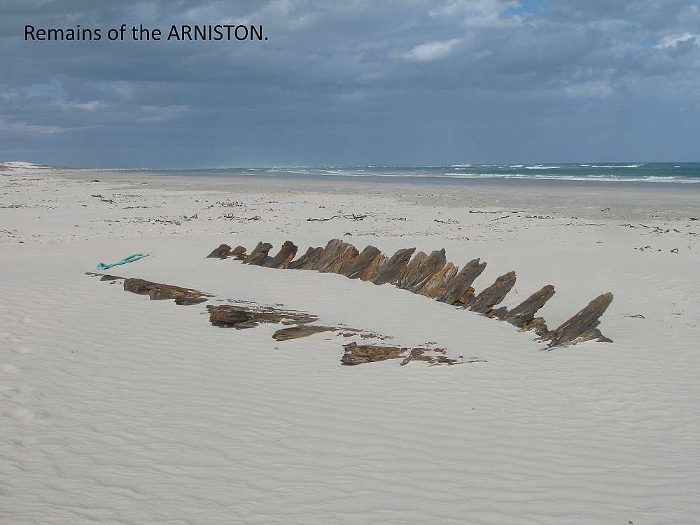 Wooden ship remains sticking out of the sand