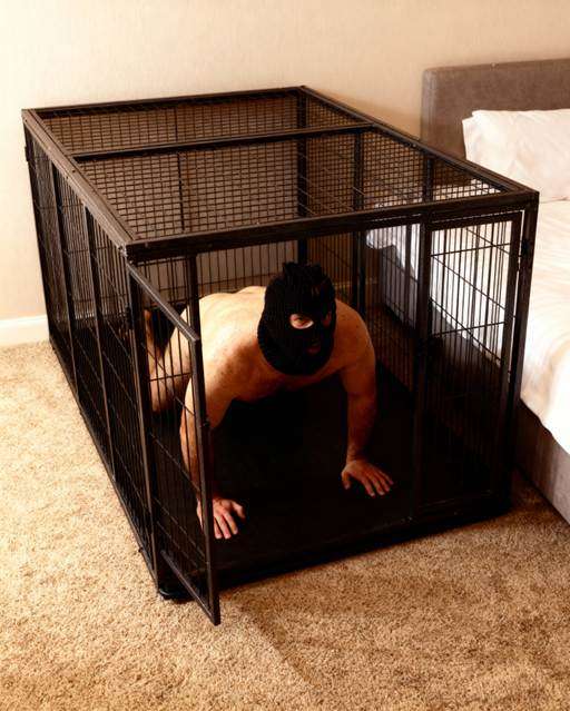 A man in a dog cage