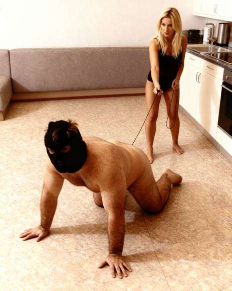 A man crawling with a woman holding his leesh