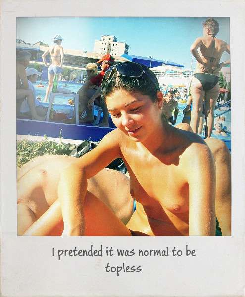 Topless woman sitting next to a pool surround by lots of people