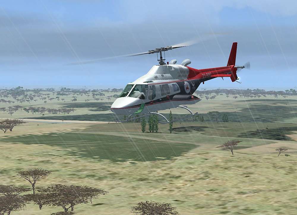 Enroute to Sabi-Sabi, Adrian flies the Bell 222 helicopter just a bit higher that tree top height. The rain is pouring down and the clouds are grey and thick overhead.