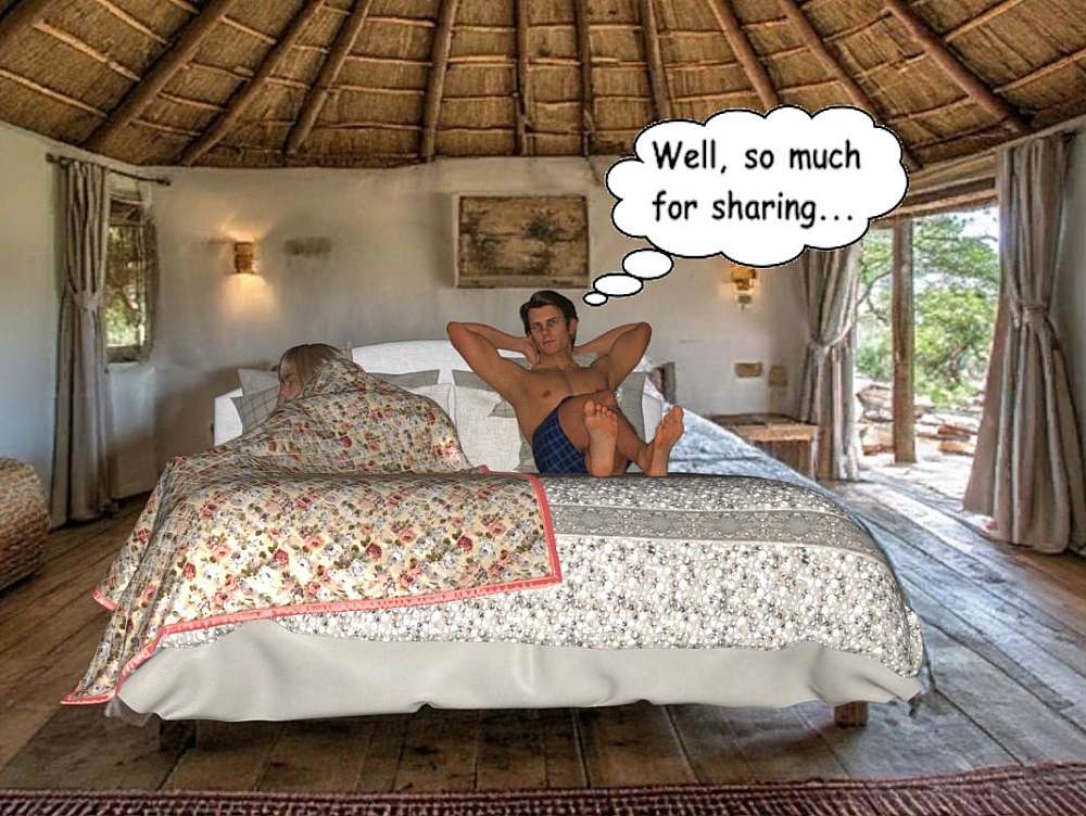 The image captures an awkward morning-after scene inside a rustic, thatch-roofed bungalow at Sirheni. The view is centered on a large bed where Adrian and Kait are sharing a cramped space. On the left, Kait is completely submerged under a heavy, floral-patterned quilt, showing only a shock of blonde hair as she snoozes, turned away from the center. To her right, Adrian sits upright and shirtless in blue chequered boxers; he leans back against the headboard with his hands behind his head, his expression one of dry resignation. A thought bubble above him reads, ‘Well, so much for sharing...’, emphasising the cramped sleeping arrangements. The room’s architecture features a dramatic, conical ceiling with radial wooden ribs leading up into thick thatch. In the background, open sliding glass doors reveal a sun-drenched wooden deck and the rugged, rocky terrain of the South African bush. The light is bright and natural, contrasting the shaded, intimate interior of the bungalow with the vast, wild landscape just steps away.