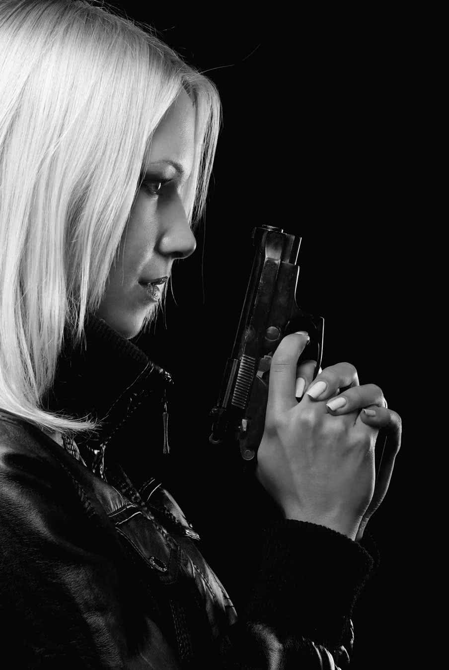 image of blond Em holding gun in black leather jacket.