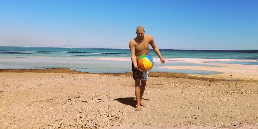 Man playing with beach ball on the beach